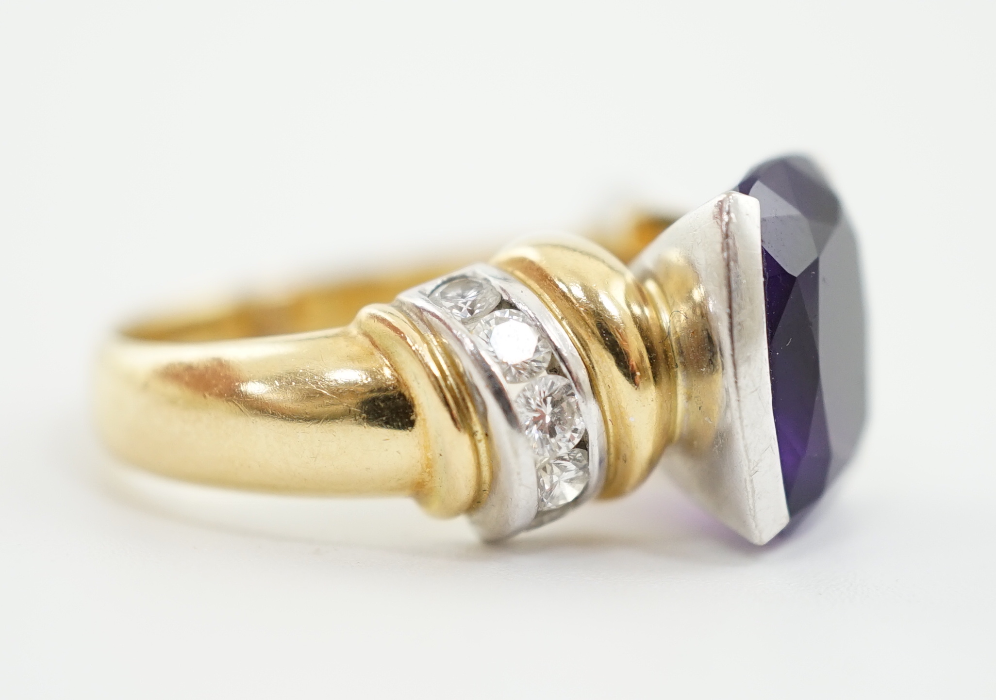 A modern 18ct gold and single stone cushion cut amethyst set dress ring, with ten stone round brilliant cut diamond set shoulders